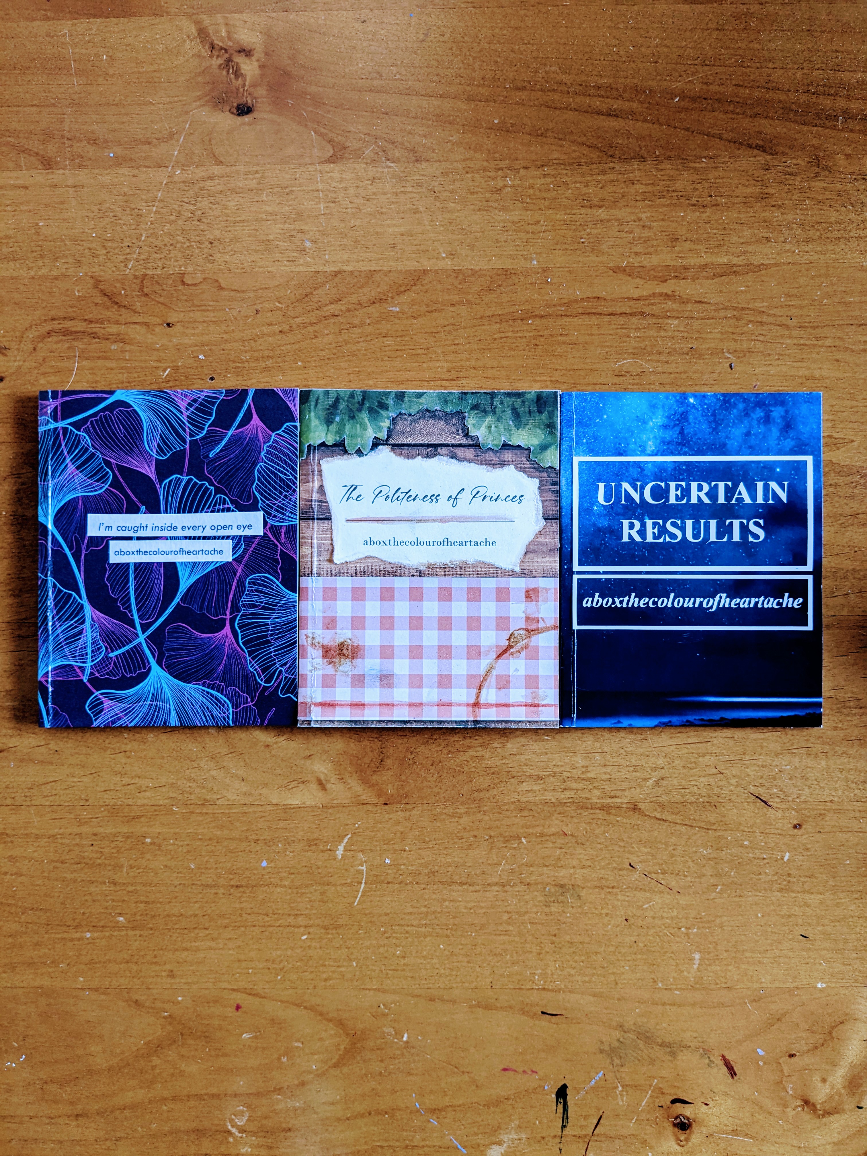 photo of three zines of aboxthecolourofheartache's work